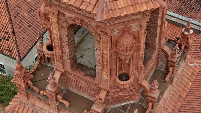 Aerial view of the intricate terracotta architectural details of the Grace United Methodist Church tower, featuring ornate carvings and red clay tile roofing in St. Augustine, Florida, United States.