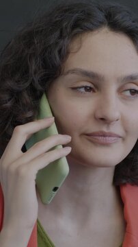 Joyful young woman speaking on mobile phone laughing on black color background. Cellphone communication and happy person concept.