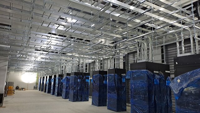 Data center computer room under construction with PDU cabinets and overhead cable trays