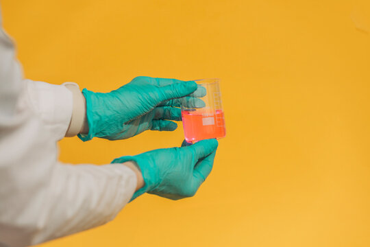 Scientist hold beaker with pink liquid in laboratory