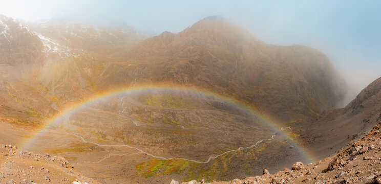 Rainbow over misty Cayambe Volcano crater in Ecuador
