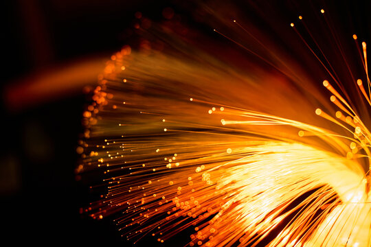 Glowing fiber optic strands form abstract data light trails