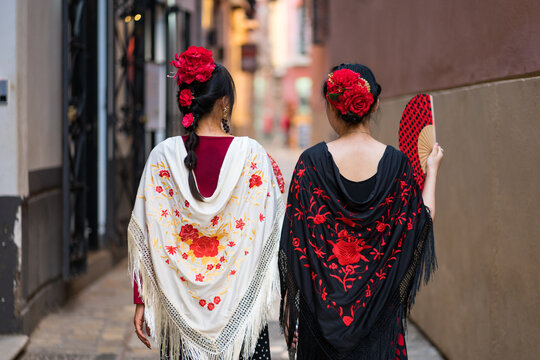 Women in flamenco dresses at Malaga fair from behind