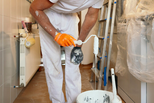 Professional painter apply white paint during home renovation