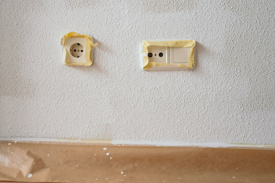 Masked electrical outlet and switch during wall painting