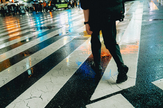 Pedestrian cross Tokyo street in rain at night