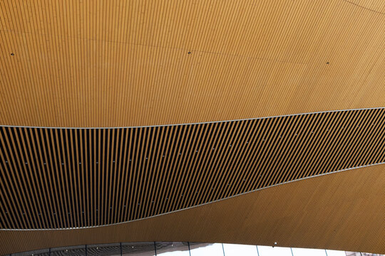 Wavy wooden ceiling with curved slatted architectural pattern