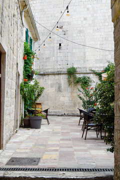 Historic stone alley with cafe terrace and string lights