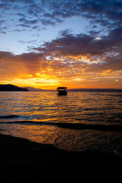Tranquil boat at sunset over Lake Toba