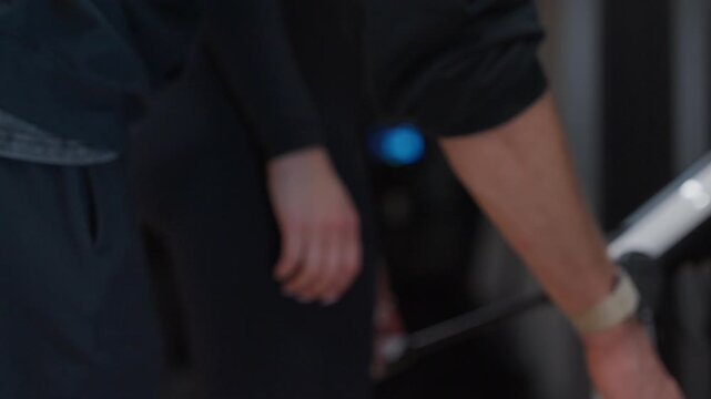 Shallow-focus detail shows a woman's hand reaching down to take the electrode handles of a body composition analyzer.