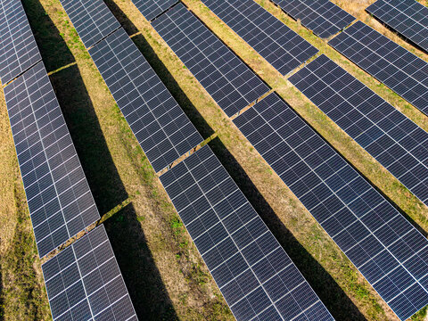 Aerial view of rows of solar panels installed in a field at a solar farm in Targu Secuiesc, Covasna County, Romania.