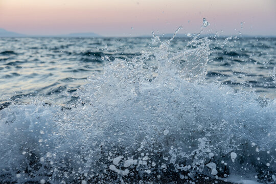 Ocean wave splash at sunset on the open sea