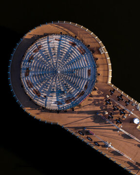 Aerial view of the circular pier structure on the Vistula river featuring a radial roof design and wooden deck with seating in Plock, Masovian Voivodeship, Poland.