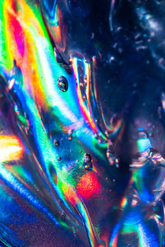 Iridescent liquid texture with rainbow reflections and bubbles