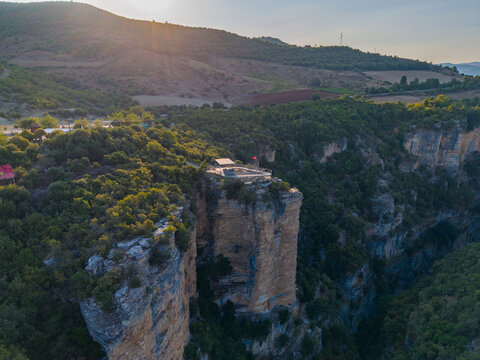 Aerial view of Osumi canyon with its dramatic limestone cliffs and lush green vegetation under the warm light of the golden hour in Dhores, Berat County, Albania.
