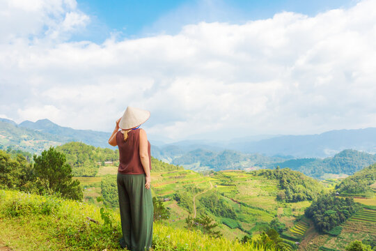 A woman admires the breathtaking scenery of rice terraces. Mu Cang Chai rice terraces on the mountain slopes.