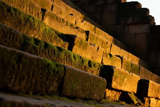 Sunlit stone steps covered in moss, showing ancient architecture details