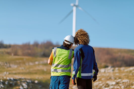 Two Engineers Inspect Wind Turbine on Rural Wind Farm During Renewable Energy Site Visit