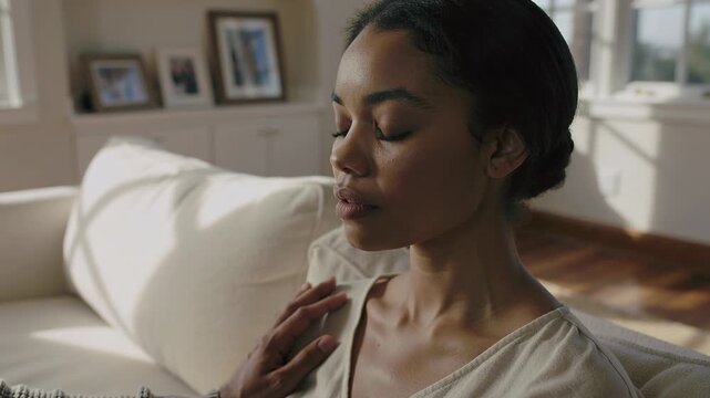 Approaching man placing hand on woman in light blouse on couch, woman closing eyes, returning touch