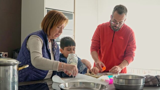 Grandmother, father and child baking Christmas cookies at home, enjoying family time and holiday traditions.