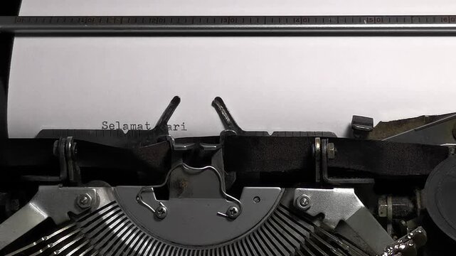 Close Up Overhead Shot of Vintage Typewriter Typing Selamat Hari Batik Nasional on Paper
