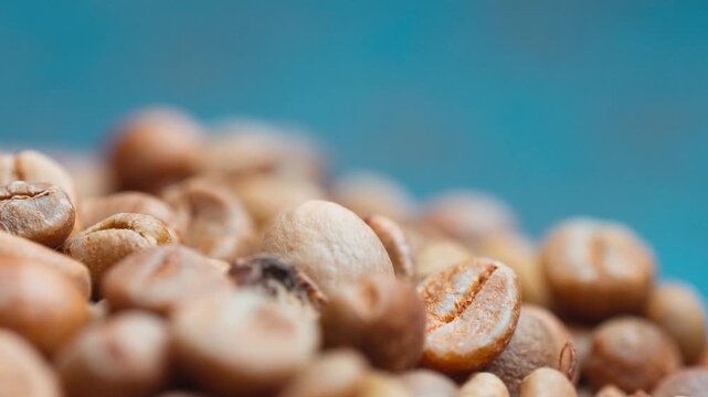 Macro close up shot of unroasted raw green coffee beans heap with selective focus.
