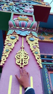 Woman exploring the colorful traditional architecture of Gue Monastery in Spiti Valley, Himachal Pradesh, India, showcasing intricate Tibetan Buddhist design, cultural heritage and mountain tourism.
