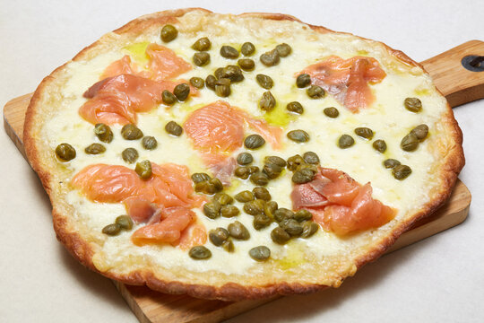 Italian pizza with smoked salmon, caper and melted cheese