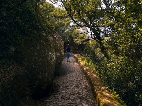 Hiker on cobblestone forest path in Sintra, Portugal