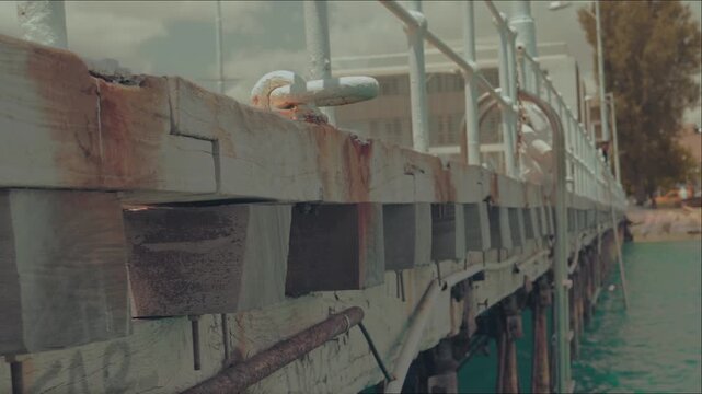 Textured old boards and metal moorings of a sea berth in soft focus,