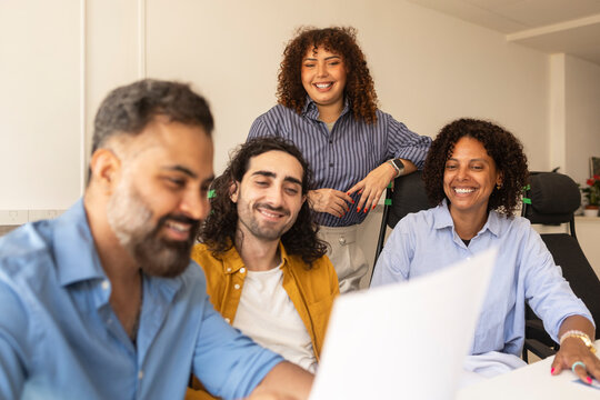 Diverse team discuss document in coworking office