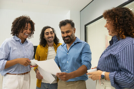 Coworking office team reviewing document during coffee break