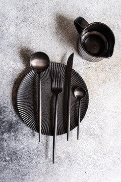 Black table setting with textured plate and cutlery