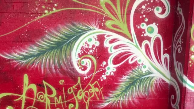 A highly detailed and dynamic piece of street art (graffiti or a mural) on a bright red wall.