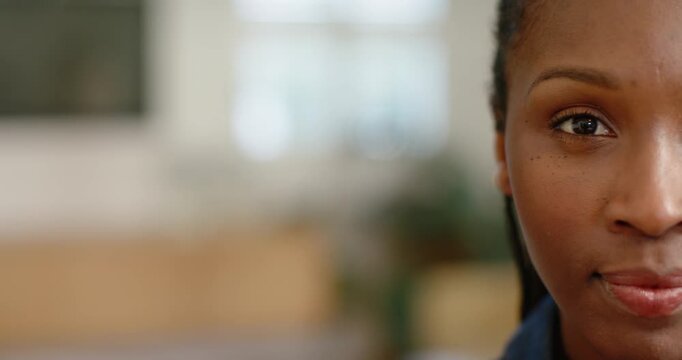 Adult African American woman at home in blue blinking from window light, plant visible, copy space
