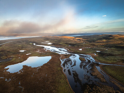 Aerial view of the scenery over a mountain range with clouds and fog - Iceland