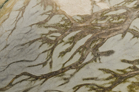 Aerial view of intricate glacial river patterns forming braided channels across the sandy landscape of Hofn, Sveitarfelagid Hornaf, Iceland.