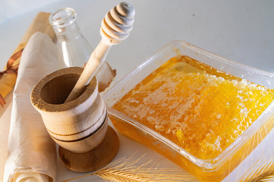 Fresh Honeycomb in Container with Wooden Dipper, Mortar and Wheat