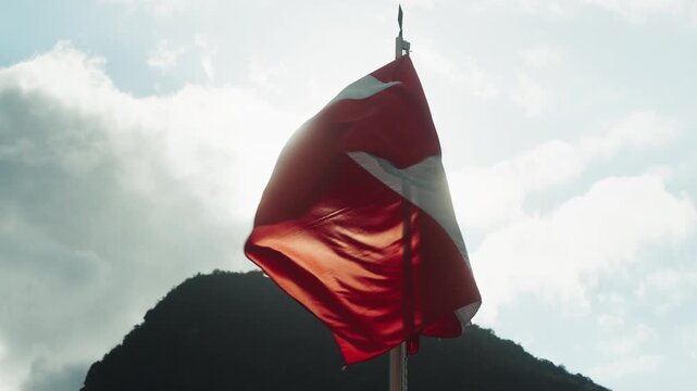 Panoramic close-up of the red and white national flag of Peru waving against the Andean landscape