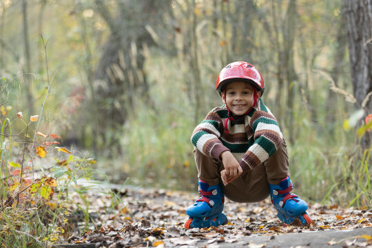 Cute school child, boy, riding roller skates, skating on the street autumn