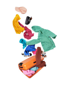 Colorful casual clothes flying out of an open orange suitcase isolated on a transparent background.