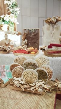 Luxury dry fruits gift hamper tray with assorted nuts and floral decoration on table at Indian wedding ceremony