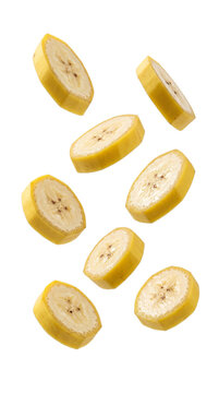 Multiple fresh banana slices falling or floating against a clean white background, showcasing the fruit's texture and color.