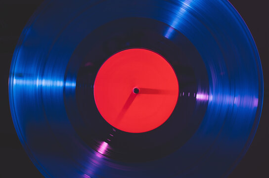Vinyl record spinning under colorful light