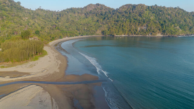 Aerial panoramic view of Pujiharjo beach bay surrounded by green hills in Malang East Java