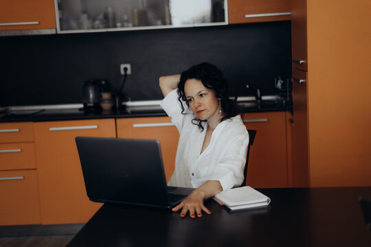 Woman leans back beside laptop during home work session creating realistic scene about digital fatigue work life boundaries mental load remote work stress recovery and sustainable productivity habits.