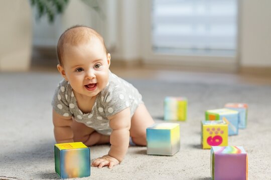 Happy baby crawling on all fours among colorful blocks