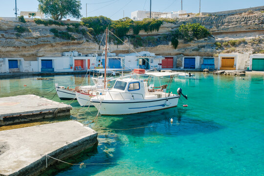 Charming fishing boats at Mandrakia harbor in Milos, Greece under sunny skies