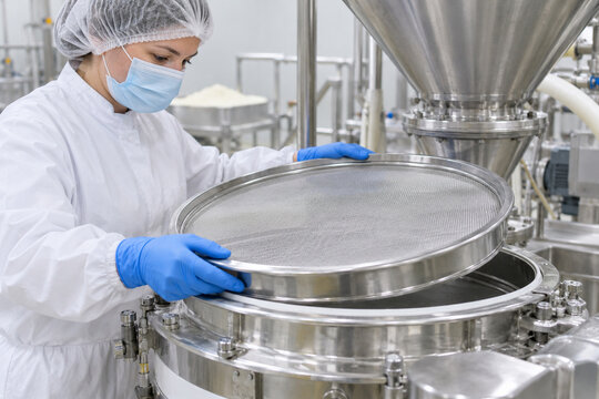 Infant Formula Technician Inspecting Dry Blend Sieve Before Production Restart