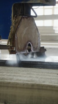 Circular saw cutting a precast concrete slab with water at a concrete factory